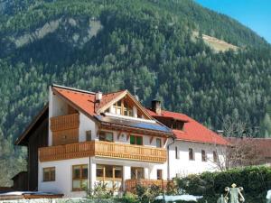 a house with a red roof on a mountain at Ferienhaus Monz in Pfunds