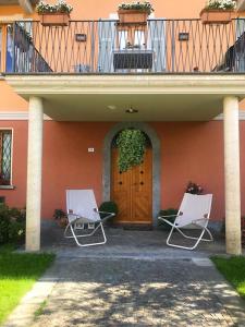 two chairs sitting in front of a house with a door at Bellagio & sunset - Lezzeno Cà Bareta in Lezzeno