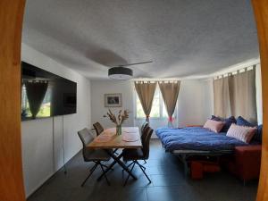 uma sala de estar com um sofá e uma mesa com uma cama em L'ANGOLO DEI SAPORI em Rueun