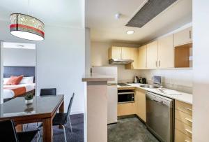 a small kitchen with a table and a bed at Seaside Oasis with Balcony along the Esplanade in Darwin