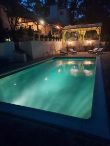 uma piscina iluminada à noite em Vila avec, piscine, tennis. em Rivaux