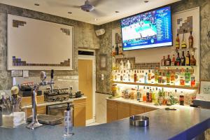 a kitchen with a bar with a tv on the wall at Apollon Hotel Apartments in Platanes