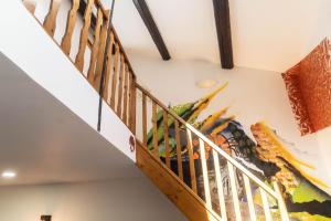 a staircase in a house with a painting on the wall at Duplex Street-Art Centre-Ville Netflix Disney by Rentabao in Avignon