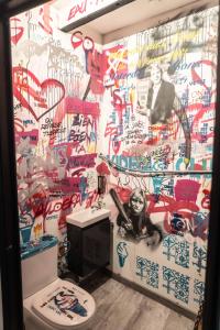 a bathroom with a wall covered in graffiti at Duplex Street-Art Centre-Ville Netflix Disney by Rentabao in Avignon