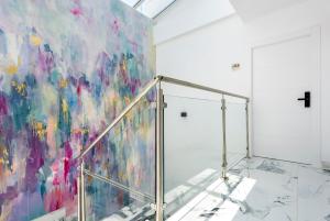 Quivir Apartamentos Deluxe Casa del Arco في أندوخار: لوحة على جدار غرفة مع درج