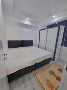 a small room with a bed and a sink at Aloha Airport Guest Home in Altınkum
