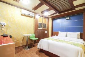 首爾的住宿－Couple Motel，一间卧室配有一张大床、一张桌子和一张书桌
