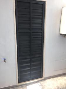 a black shutter door on a white wall at Berenice Suite in Taranto