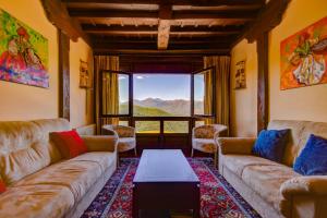 a living room with couches and a table and a window at Casa Lamadrid in Cahecho