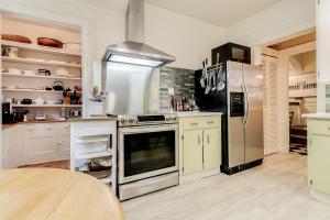 a kitchen with a stainless steel refrigerator and white cabinets at Four Bedroom Rosedale Home in Toronto