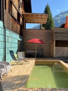 a red umbrella sitting on top of a building at Lenai & Linai Apartments in Lech am Arlberg