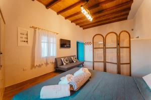 a bedroom with a bed with a blue blanket at Kythera secrets suites in Viarádhika
