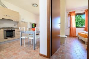 a kitchen and dining room with a table and chairs at Residenza Principina in Principina Terra