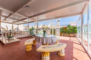 a room with a table and chairs on a balcony at Apartamentos Los Delfines in El Médano