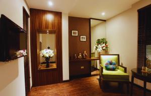 ハノイにあるHotel Emerald Waters Classyの鏡と椅子と花のある部屋