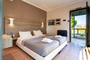 a hotel room with two beds and a television at Kalogria Summer Retreats - Seimeio Strofilia, Sunny Vibes in Kalogria