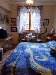 una camera con letto e piumone blu di L'apparita Camere a Pienza