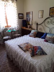 ein Schlafzimmer mit einem Bett mit einer weißen Tagesdecke in der Unterkunft L'apparita Camere in Pienza