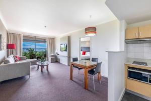 cocina y sala de estar con mesa y sofá en Breezy Harbourfront Resort with Seaviews & Pool, en Darwin