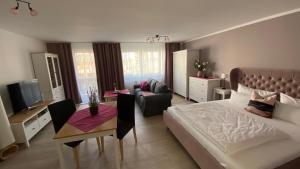 ein Schlafzimmer mit einem Bett, einem Tisch und einer Couch in der Unterkunft City-Appartement 12.3. in Zwickau