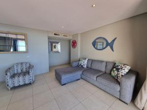 a living room with a couch and a chair at Accommodation Front - Immaculate 4 Sleeper with Ocean & Harbour Views in Durban