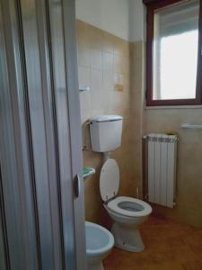 bagno con servizi igienici bianchi e finestra di Casa Vacanze Sunshine a Scanzano
