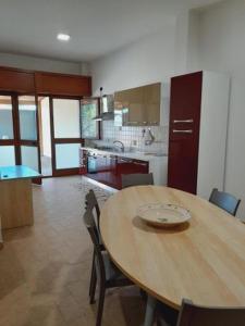 a kitchen with a wooden table and chairs in a room at Casa Vacanze Sunshine in Scanzano