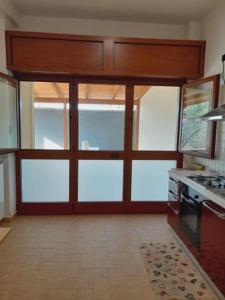 a kitchen with a stove and a large glass door at Casa Vacanze Sunshine in Scanzano