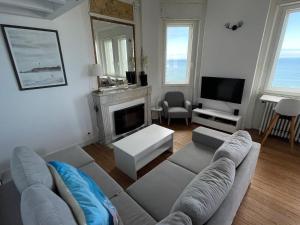 uma sala de estar com um sofá e uma lareira em 1ère ligne Mer Appartement 7 personnes. em Biarritz