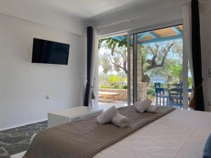 a bedroom with a bed with two pillows on it at Casa Marimar Boutique Bungalows & Suites in Porto Heli