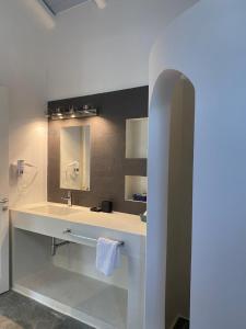 a bathroom with a sink and a mirror at Casa Marimar Boutique Bungalows & Suites in Porto Heli