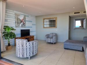 a living room with two chairs and a television at Accommodation Front - Immaculate 4 Sleeper with Ocean & Harbour Views in Durban