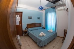 Hotel Giglio في لامبيدوسا: غرفة نوم عليها سرير وفوط