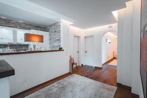 a kitchen with white cabinets and a brick wall at Majestic Apartment by Majestic Resorts Dolomites in Riscone +5 photos