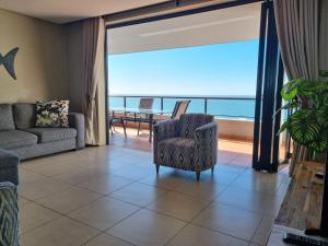 a living room with a chair and a view of the ocean at Accommodation Front - Immaculate 4 Sleeper with Ocean & Harbour Views in Durban