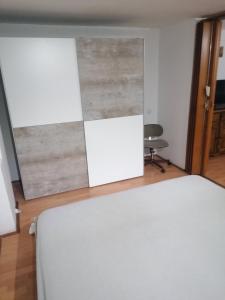 a bedroom with a white bed and a wooden floor at Apartman Oaza Olja in Belgrade