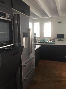 uma cozinha com um frigorífico de aço inoxidável e um balcão em 1ère ligne Mer Appartement 7 personnes. em Biarritz