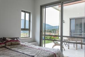 una camera con letto e un balcone con finestre di Our Mount Meron Orchard - your perfect getaway a Tsiv'on