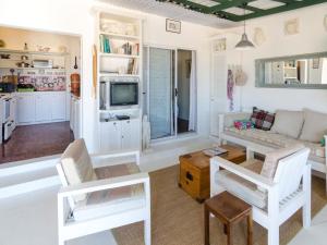 un soggiorno con sedie bianche e un divano di Beach Cottage Kleinzee a Kleinsee