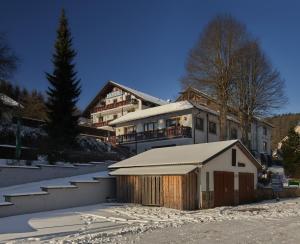 a building with a snow covered garage in front of it at Hotel Jägerklause in Schmalkalden