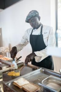 a man is preparing food in a kitchen at Hotel Blau Parc in San Antonio