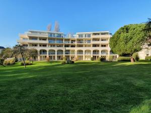 ein großes Gebäude auf einem saftig grünen Feld in der Unterkunft Appartement avec grande terrasse dans un magnifique parc à 5 minutes de la plage in La Baule