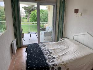 Schlafzimmer mit einem Bett und Blick auf einen Innenhof in der Unterkunft Appartement avec grande terrasse dans un magnifique parc à 5 minutes de la plage in La Baule