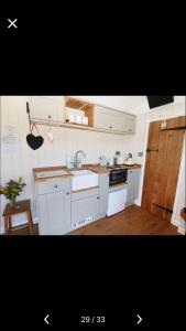 una cocina con armarios blancos y fregadero en Lavender Retreat with Private Hot Tub, en Upper Hulme