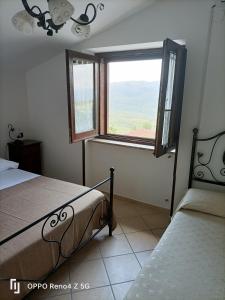 um quarto com uma cama e uma janela em Il Rifugio Longobardia Minorae em Monteforte Cilento