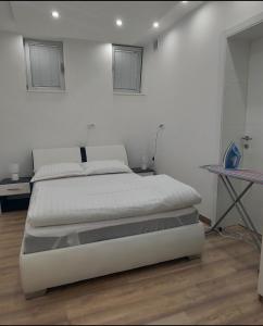 Un dormitorio blanco con una cama y una mesa. en Apartman Dona, en Banja Luka 1 foto más