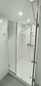 una ducha con puerta de cristal en un baño en Apartman Dona, en Banja Luka