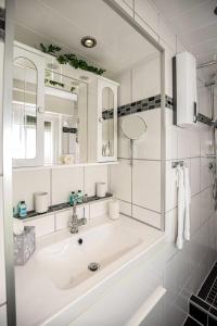 La salle de bains blanche est pourvue d'un lavabo et d'un miroir. dans l'établissement Ferienhaus Therese, à Kobern-Gondorf