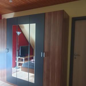 1 dormitorio con armario de cristal y escritorio en Ferienhof Kaiser, en Herrieden