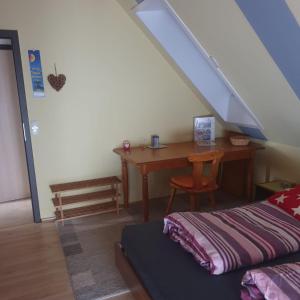Habitación con escritorio, cama y escalera. en Ferienhof Kaiser, en Herrieden